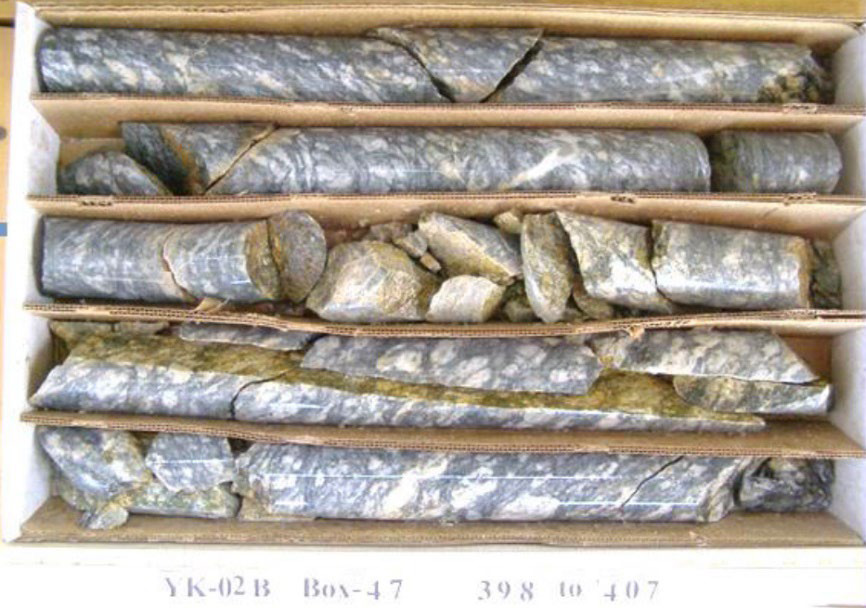 Assays from 398 to 403 ft depth yielded 0.079 wt. % Cu and 0.017 wt. % Mo with 19 ppb Au and 0.31 ppm Ag (YK-02B1)